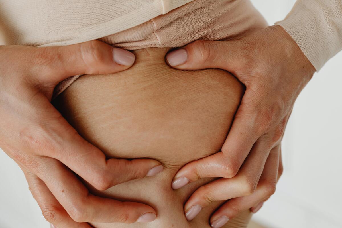 Femme observant la cellulite sur ses cuisses.